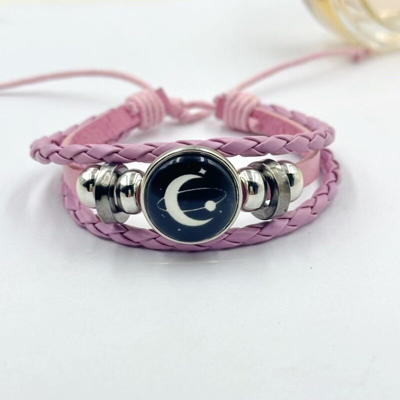 Black braided cord bracelet with a domed sea charm and flanking silver beads