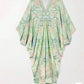 Light green floral V-neck dress laid flat showing the wide sleeves and the trimmed neckline