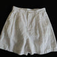 White wide-leg linen shorts shown flat, pleated high waist and above-knee length