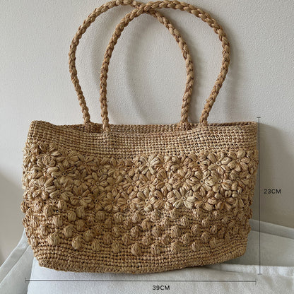 Raffia hand-woven tote bag in soft studio light, natural fiber texture
