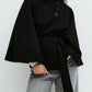 Belted cape jacket shown from the front with its self tie belt and stand collar buttons