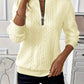 Detail of the short front zip and ring pull on a cable knit mock neck pullover
