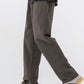 Dark gray straight leg cotton pants seen mid stride with white and green sneakers