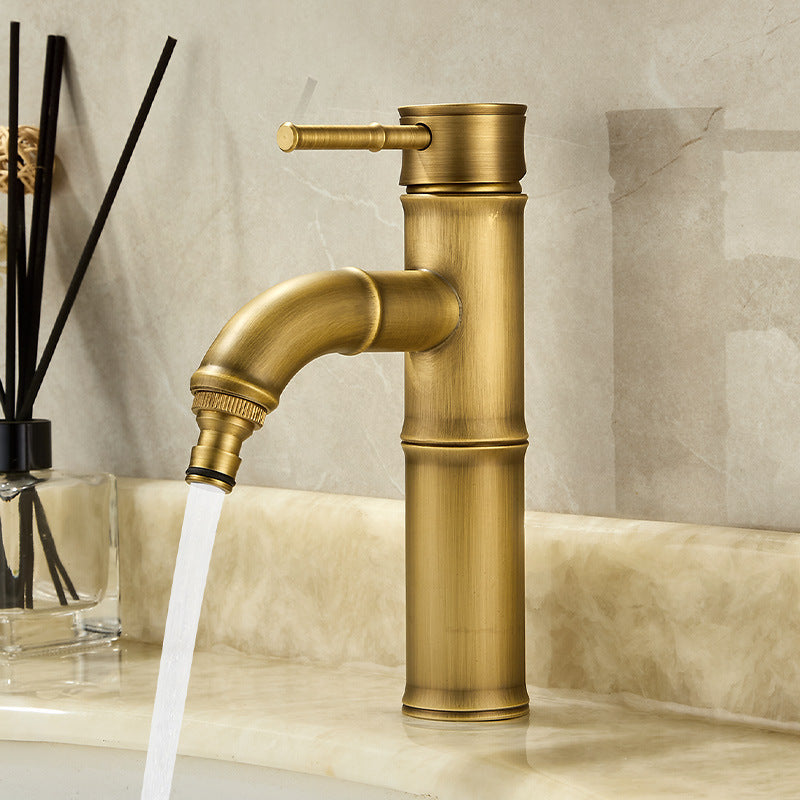 Short antique copper bamboo faucet with a curved spout running water over a countertop basin