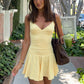 Soft yellow flared mini dress worn walking on a tree-lined sidewalk