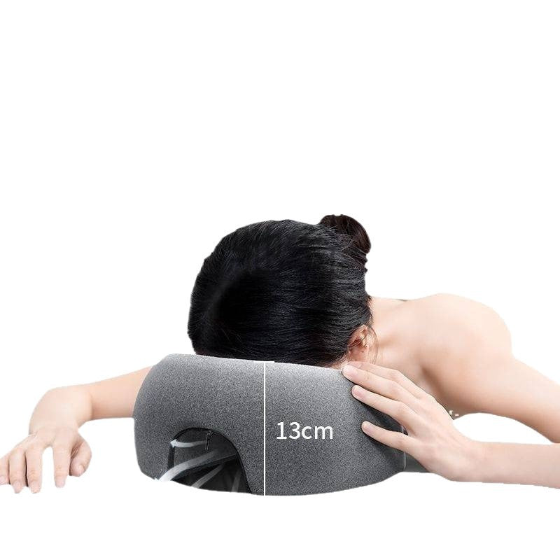 Person lying face down with their forehead and cheeks resting on the gray face rest pillow, head about 13 cm off the surface