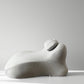 Light gray back cushion in profile on a grey ground, neck roll seated in the valley