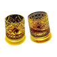 Two cut glass whiskey tumblers on white, diamond and hobnail facets lit amber at the base