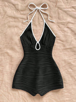 Halter neck bodycon romper in black rippled stretch fabric with a self tie bow and keyhole cutout