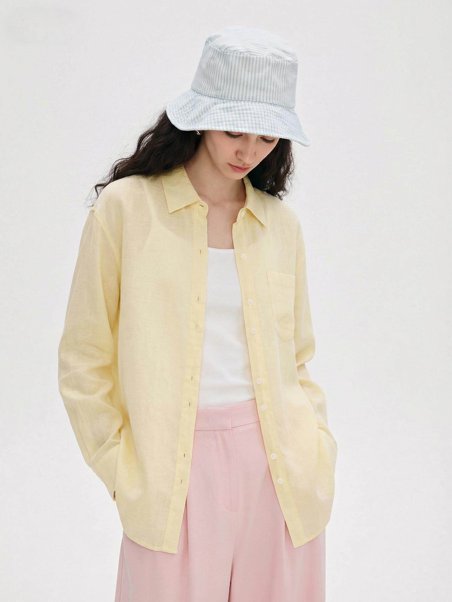 Woman in a solid colour linen button-up shirt with lapel collar layered over a cami