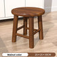 Two round wooden stools in light wood and walnut grouped near a sofa