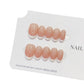 Peach milk press-on nails being applied to a natural nail