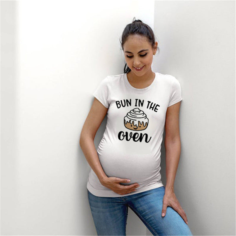 White maternity short sleeve tee with a Bun in the Oven print, round neck and side ruching, on a pregnant model