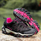 Pair of outdoor hiking shoes with lace-up fronts resting on a boulder in daylight