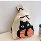 Jacquard knit wrist bag shown from the front with its loop handle upright