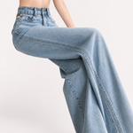 Vintage wide leg denim jeans worn on a sunlit sidewalk over loafers
