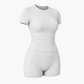 Matched yoga set with cropped tee and high waist biker shorts in soft window light
