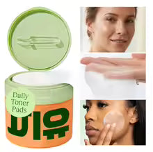 Pack of cotton facial pads on a marble counter next to skincare bottles