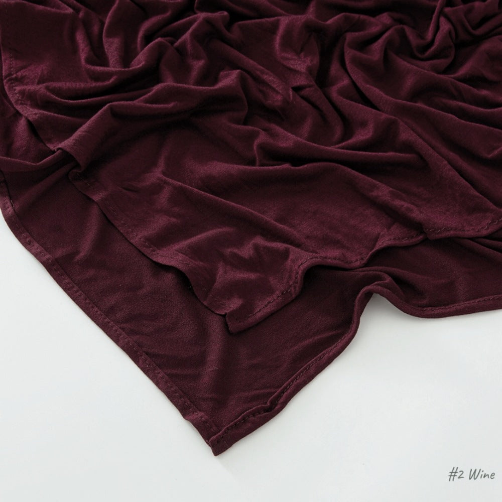 Corner of the modal cotton headscarf wrap showing the neat rolled hem and flat solid color