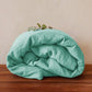 Washed pure linen duvet cover styled on a made bed in a calm minimal bedroom