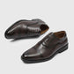 Brown mens oxford shoe on its side showing the closed lace panel, with the second shoe upright