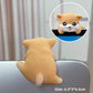 Tan shiba resin figurine seen from behind on a laptop edge with a front view inset