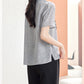 Lake Blue silk blouse with seashell motif worn seated with white trousers