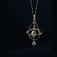 Armillary sphere pendant on a dark background, rings tilted around the central grey bead