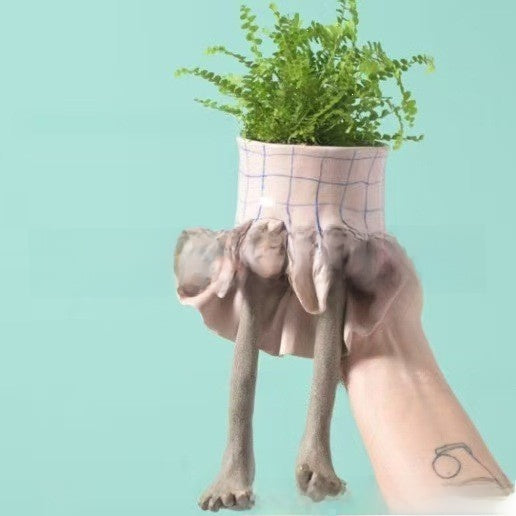 Resin lower body planter shaped like a dog body with a grid skirt holding a fern