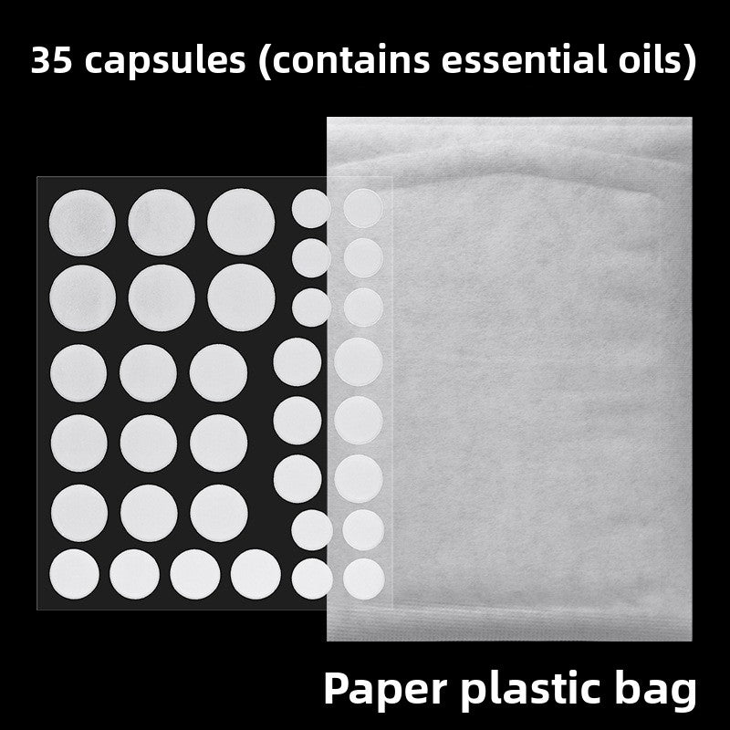 Sheet of thirty five hydrocolloid discs on black beside the plain paper and plastic sachet