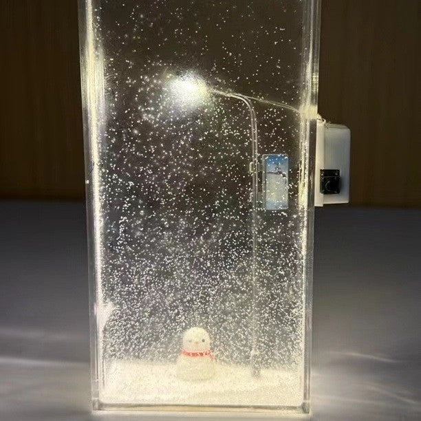 Clear acrylic Christmas light box with a slim LED street lamp glowing through fine faux snow flakes