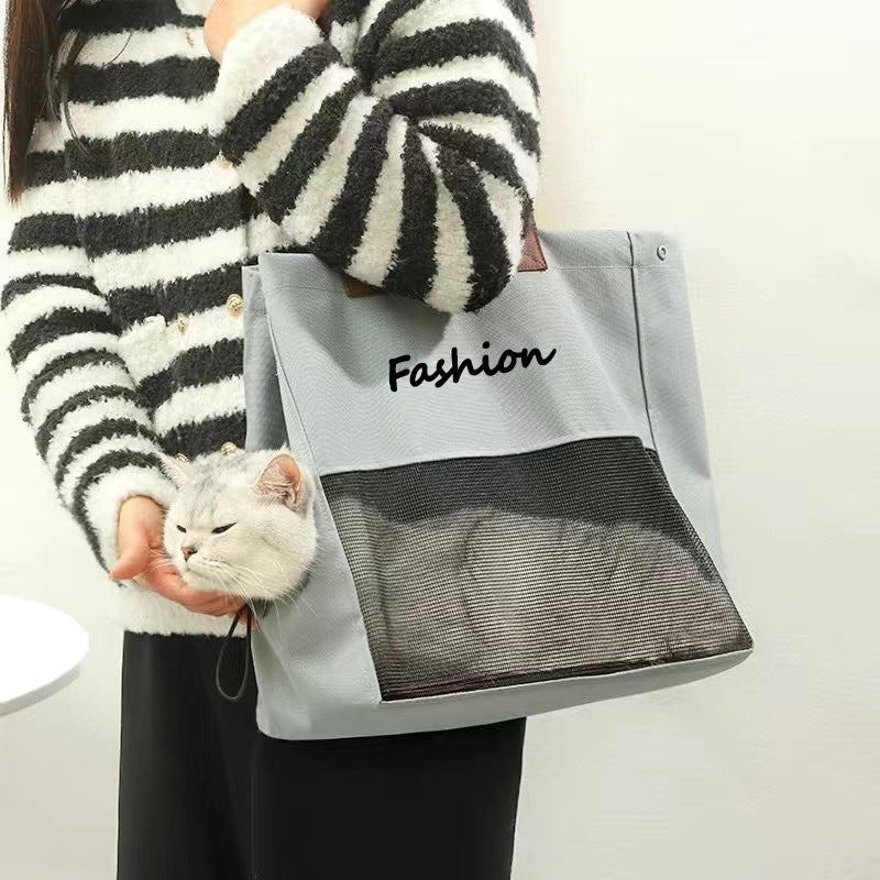 Gray cat carrier tote held on the arm with a cat resting its head out the side opening