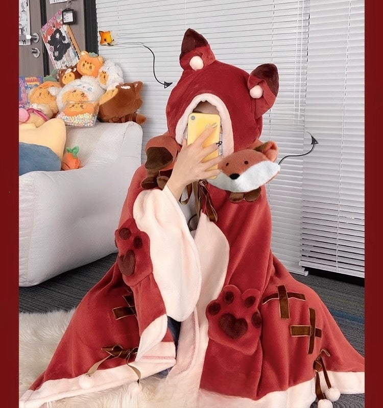 Plush animal face hood and paw cuff detail on a flannel hooded cape blanket