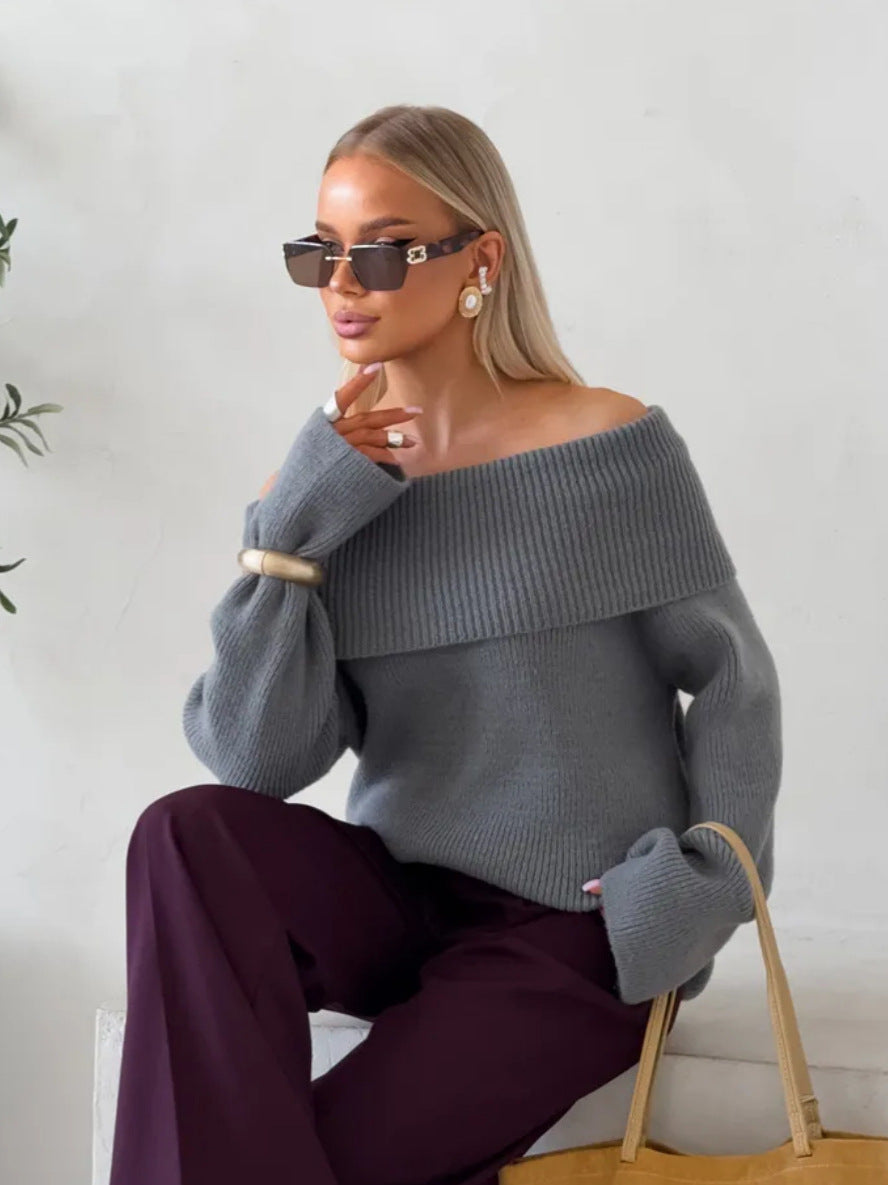 Grey off-shoulder fold-over knit sweater with wide cuffs worn with burgundy trousers