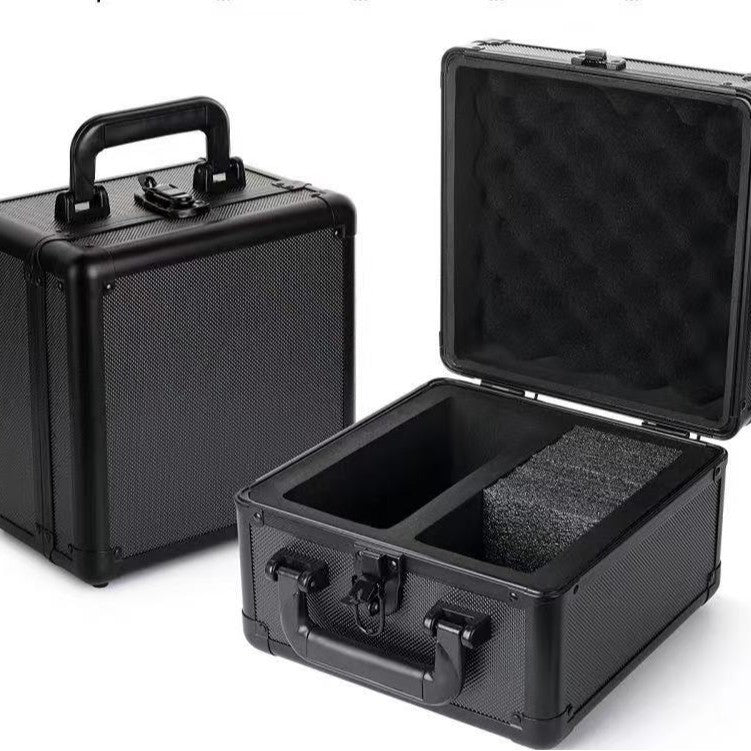 Black aluminium card storage case open beside a closed case showing the foam interior