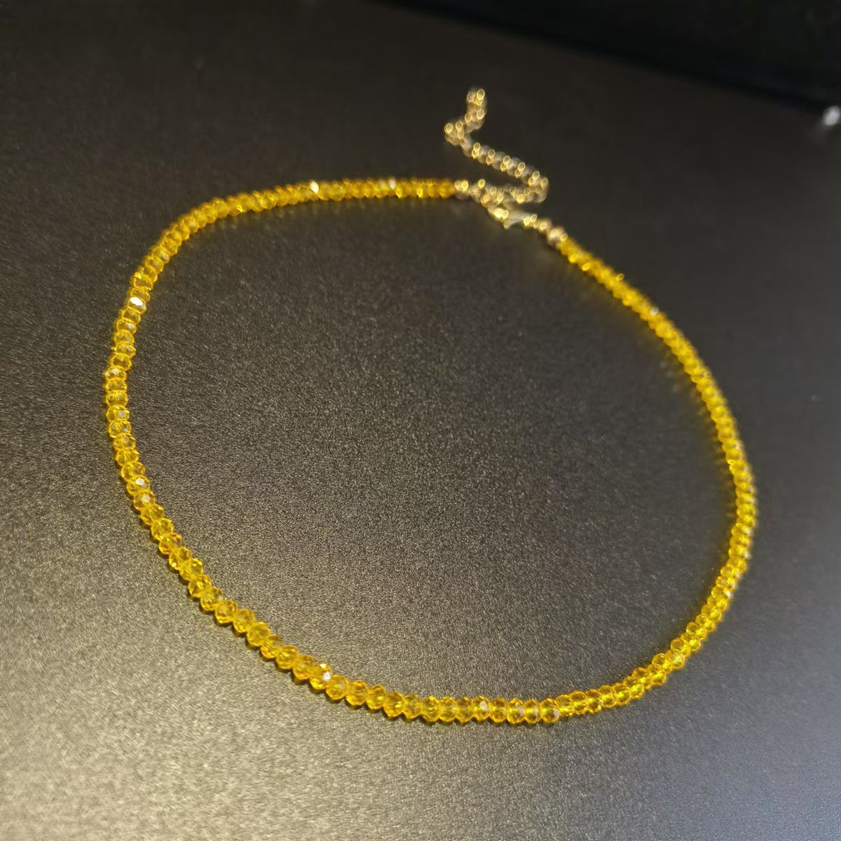 Row of faceted glass bead necklaces in several colours displayed together