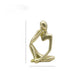 Gold abstract resin meditator figurine seated with head resting on one hand, white background
