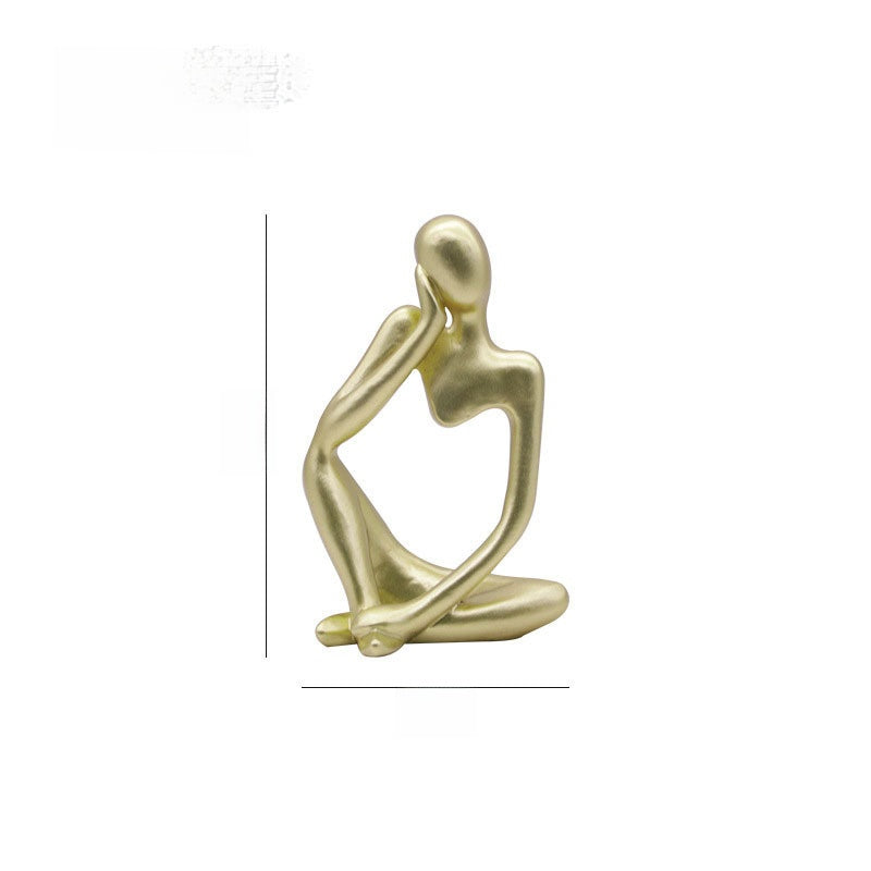 Gold abstract resin meditator figurine seated with head resting on one hand, white background