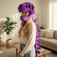 Woman wearing the purple dinosaur skeleton plush hood with the spine down her back