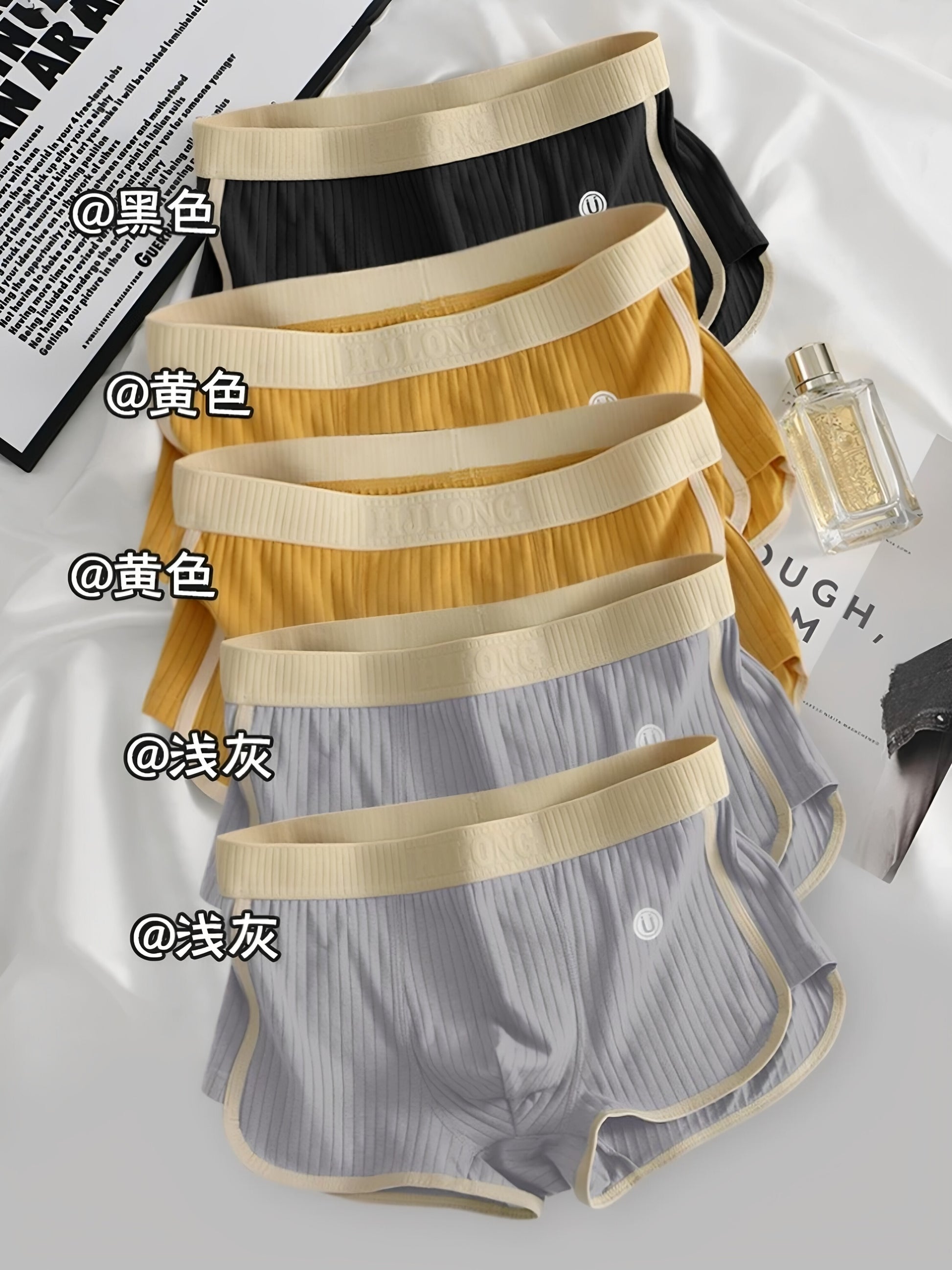 Stack of ribbed cotton boxer briefs in mixed colours on a plain background