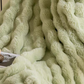 Plush throw blanket folded to show its double sided soft pile, studio shot
