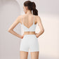 Back view of a woman in a white V-back sports bra and white high-waist shorts set, size L option