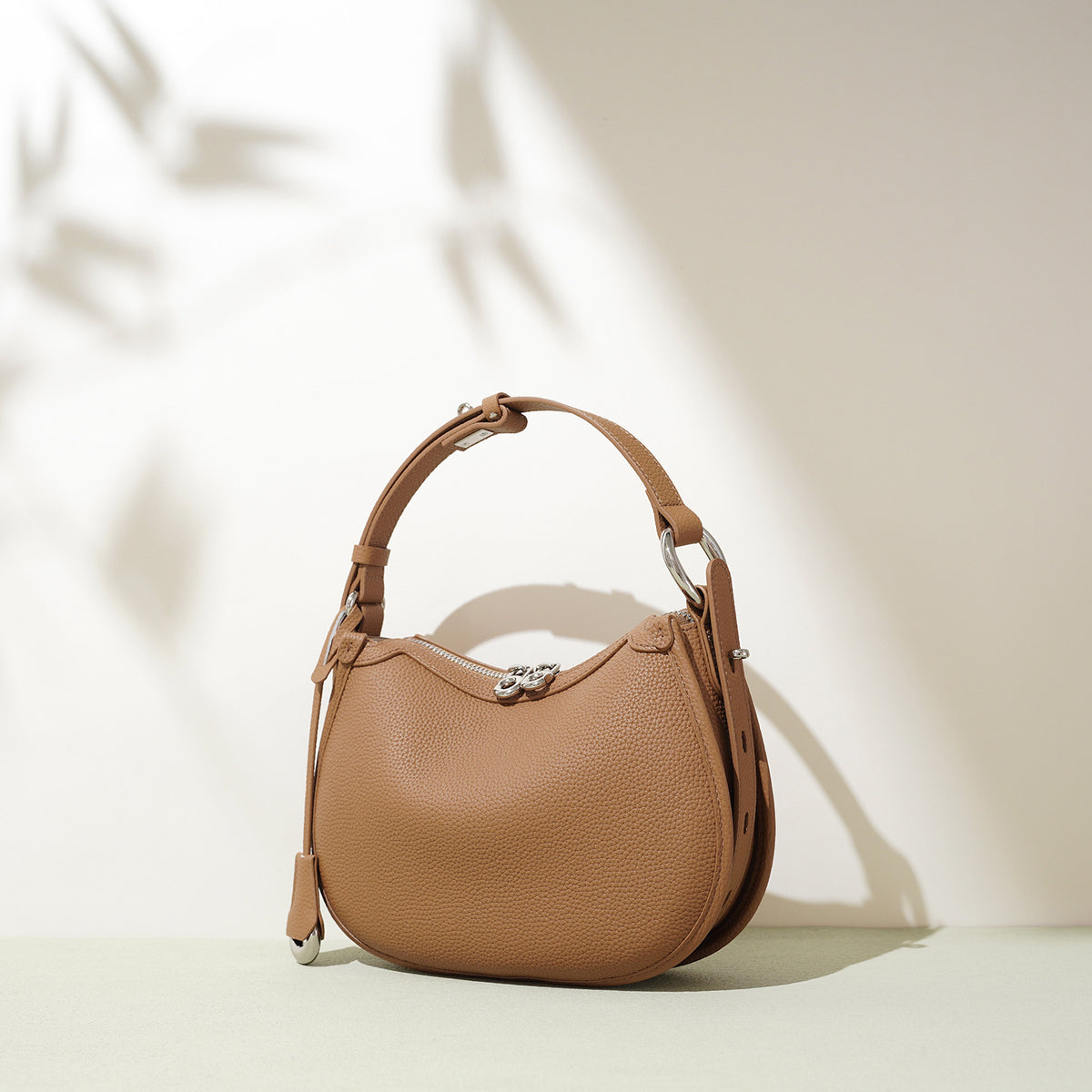 Latte brown caramel pebbled cowhide crescent bag with a short strap handle and silver tone hardware