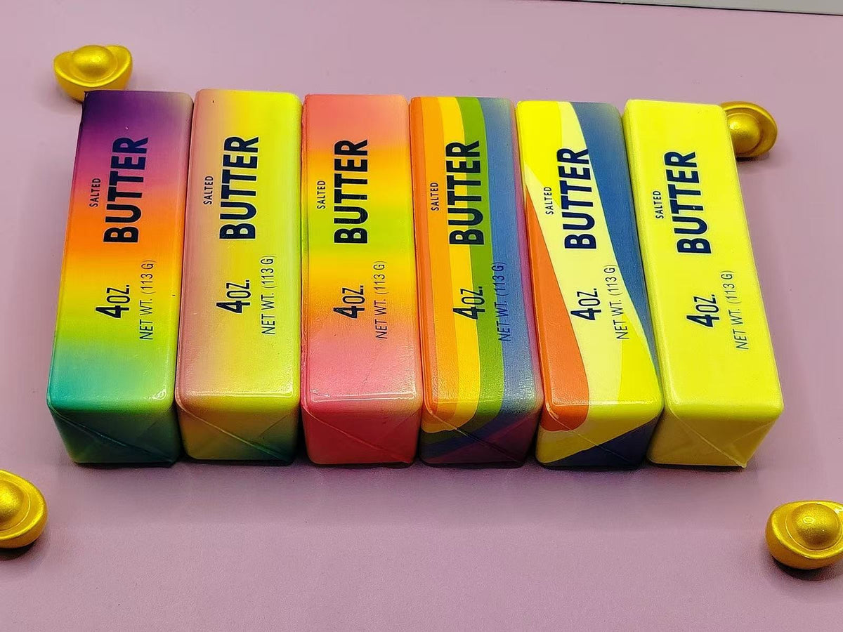 Row of six rainbow gradient butter stick squishy toys with printed butter labels, colorful 14 cm option