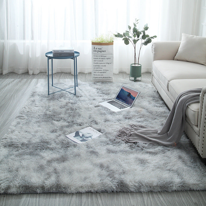 Soft shaggy polyester rug under a coffee table on a pale wood floor surface