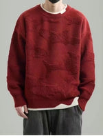 Man wearing a red whale jacquard round neck knit sweater with a cream inner collar and wavy hem