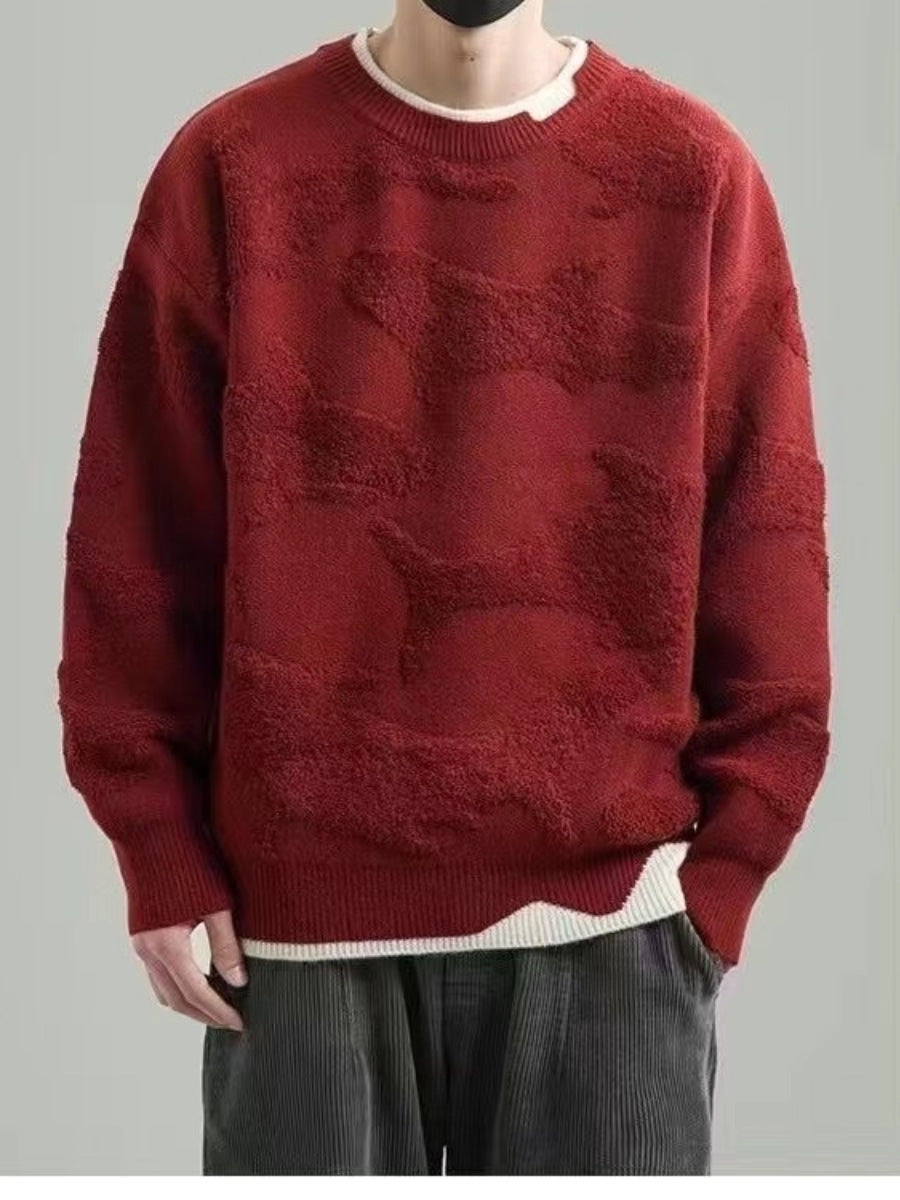 Man wearing a red whale jacquard round neck knit sweater with a cream inner collar and wavy hem