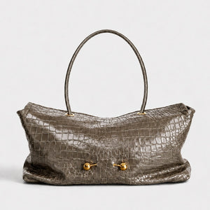 Taupe croc embossed shoulder bag with two gold ball studs and one round top handle on white