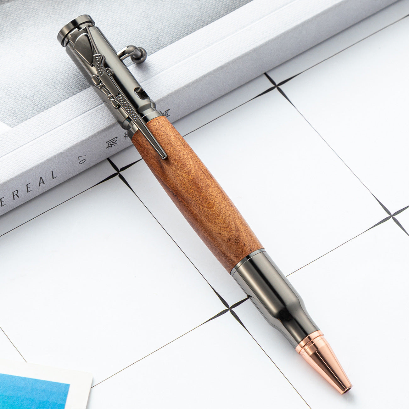 Wood barrel bolt action ballpoint pen with a copper toned bullet shaped writing tip