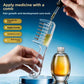 Hand filling the clear hair comb reservoir with a dropper next to a bottle of amber oil